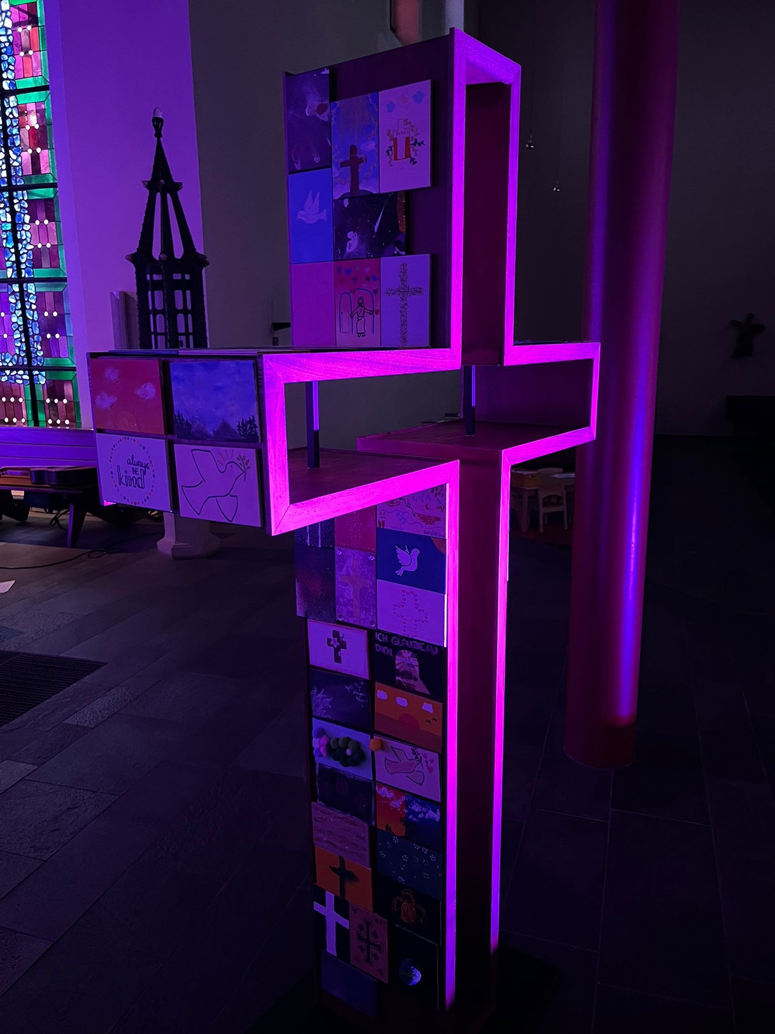Beleuchtetes Firmkreuz mit Bildern der Jugendlichen